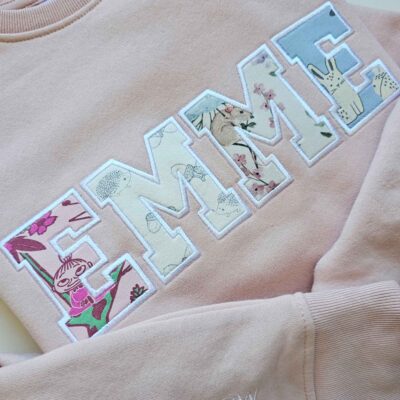 EMME pusa tikitud lapse riietest aplikatsioonina